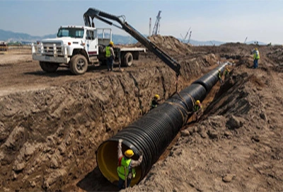 Heavy machinery and workers working together to install drainage pipes