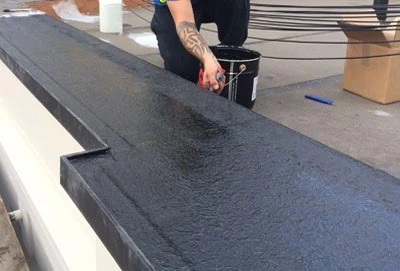 Liquid roofing being applied to a flat roof.